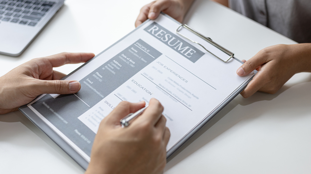 Person Looking at Resume of Person 